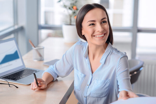 Pleasant business woman sitting at the table