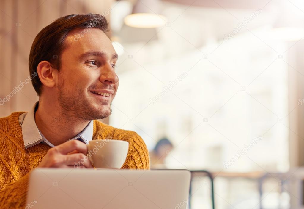 Positive man drinking coffee