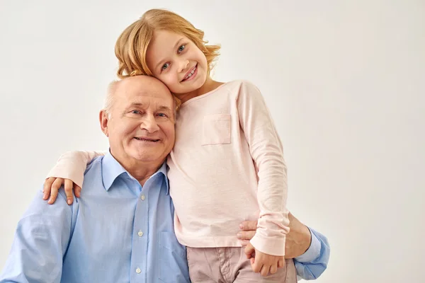 Nieta pequeña abrazando a su abuelo — Foto de Stock