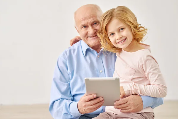 Granddaughter sitting with grandparents and table — Stock Photo, Image