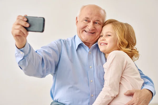 Grandfather and granddaughter make selfie — Stock Photo, Image