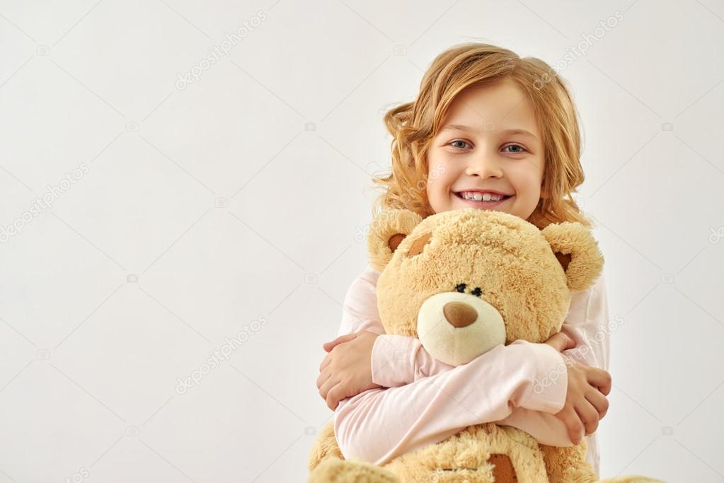 Happy little girl huging bear Stock Photo by ©Dmyrto_Z 103508518