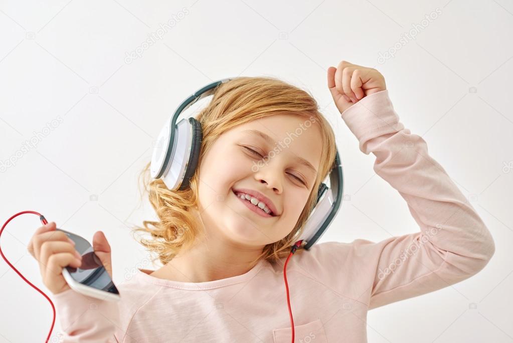 Happy girl dancing while listening to music