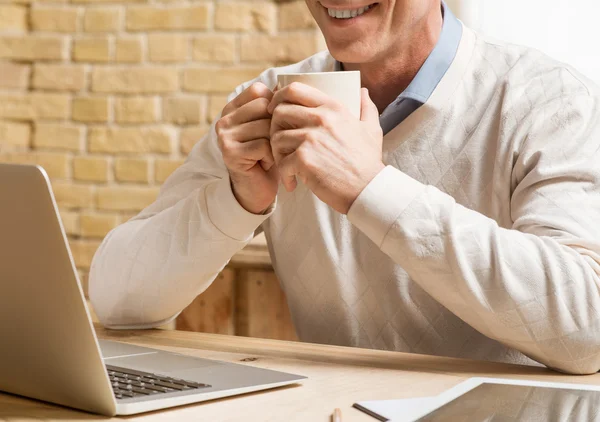 Alegre hombre sentado a la mesa — Foto de Stock