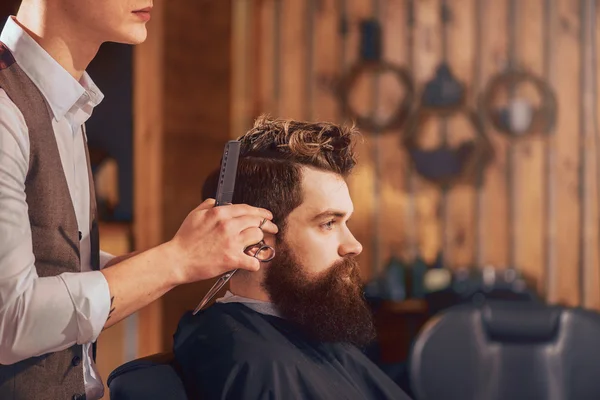 Professional barber styling hair of his client — Stock Photo, Image