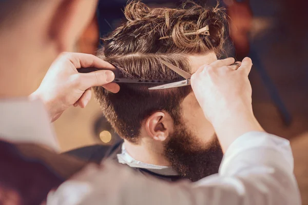 Professional barber styling hair of his client — Stock Photo, Image