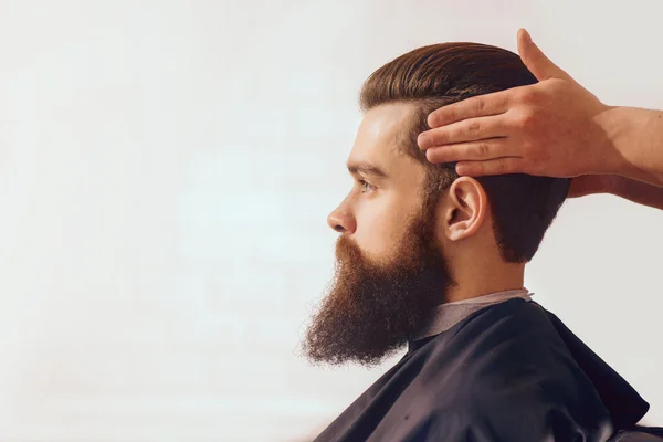 Homem barbudo sentado na barbearia — Fotografia de Stock