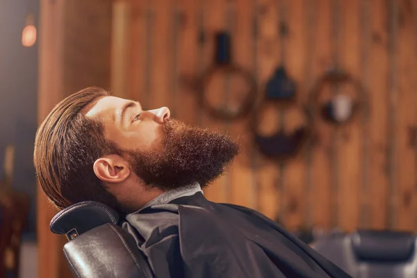 Homem agradável sentado na barbearia — Fotografia de Stock