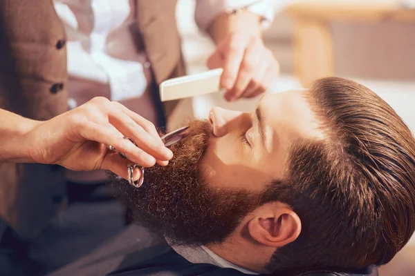 Професійний перукар для різання бороди красивого чоловіка — стокове фото