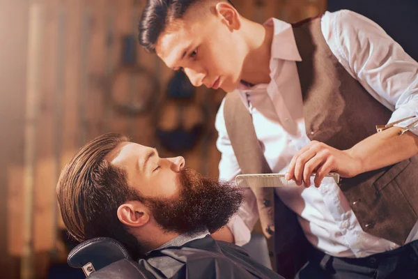 Professional barber styling hair of his client — Stock Photo, Image