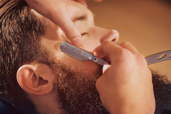 Professional barber shaving beard of his client — Stock Photo, Image