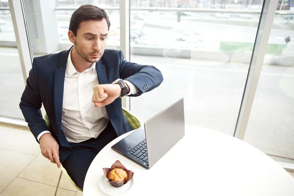 Förvånad affärsman tittar på hans armbandsur — Stockfoto