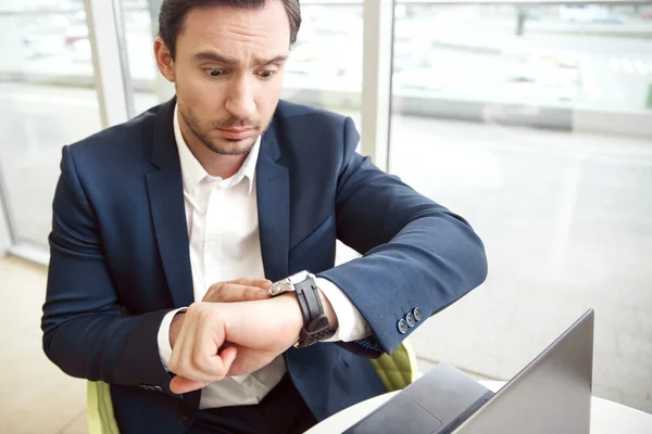 Surprised businessman looking at his wristwatch — Stock Photo, Image