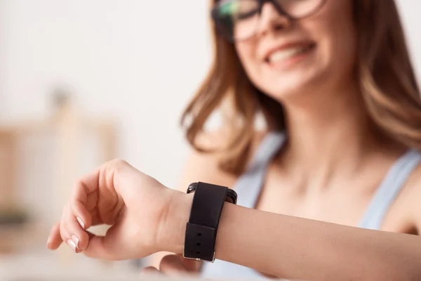 Chica alegre usando su reloj de pulsera — Foto de Stock