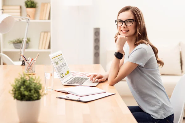 Positiv tjej som arbetar på den bärbara datorn — Stockfoto