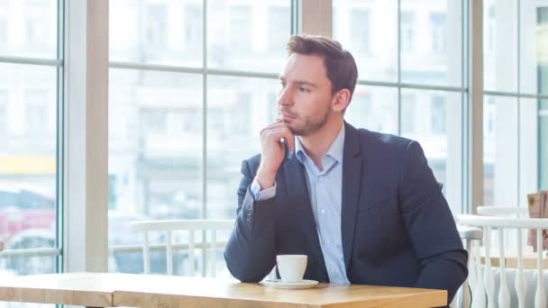 Agradable hombre de negocios sentado en el café — Vídeos de Stock