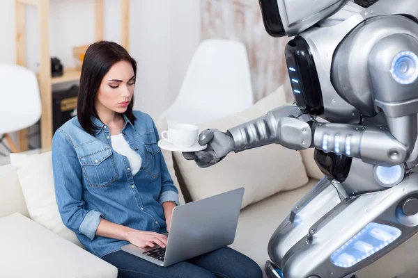 Modern robot giving cup of coffee to cheerless girl — Stock Photo, Image