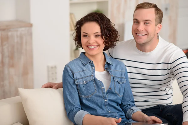 Agréable couple assis sur le canapé — Photo