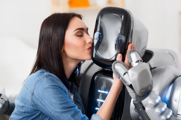 Милая девушка целует робота — стоковое фото