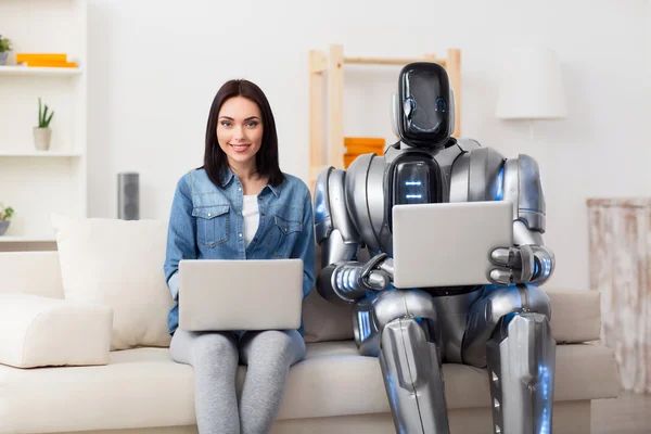 Positive girl and robot using laptops — Stock Photo, Image