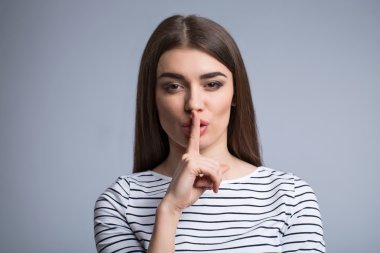 Yüzünün önünde parmağını tutan kız