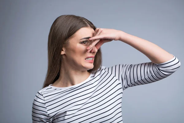 Menina agradável fechando o nariz — Fotografia de Stock