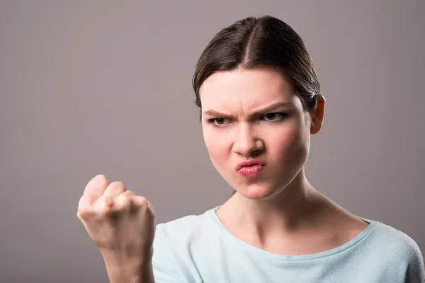 Angry girl holding hand in fist — Stock Photo, Image