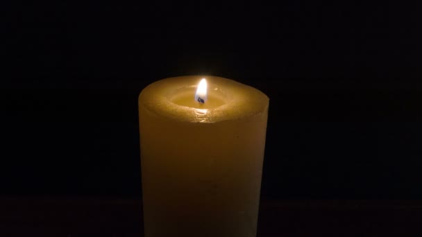 Восковая свеча горит в темноте — стоковое видео