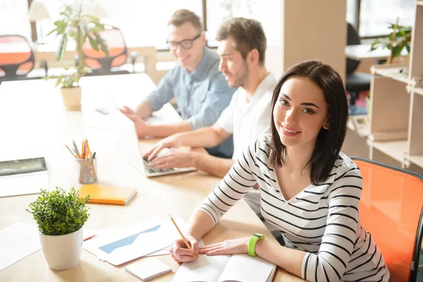 Positiv tjej sitter vid bordet — Stockfoto