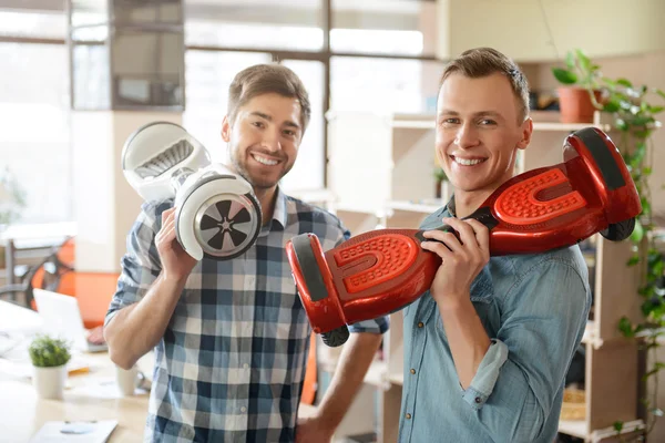 Positive smiling  men holding  gyro scooters — Stock Photo, Image