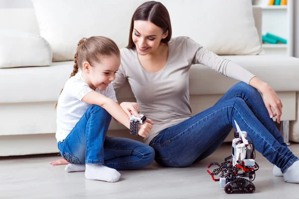 Mãe agradável e sua filha brincando com robô — Fotografia de Stock