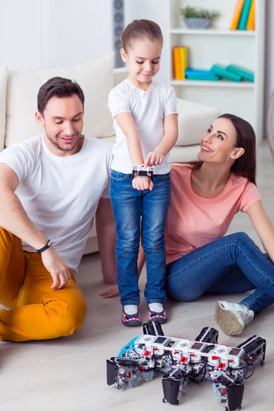 Famiglia positiva che gioca sul pavimento con sua figlia — Foto Stock