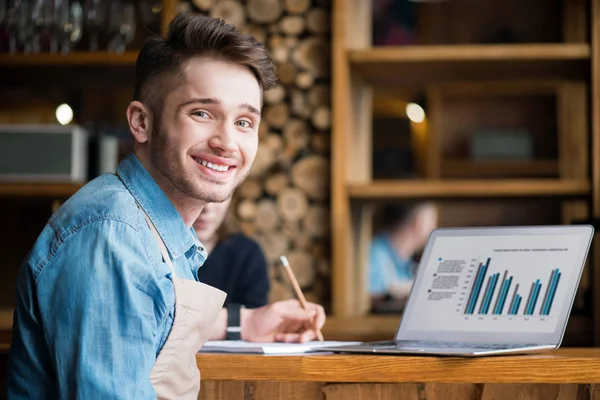 Pleasant waiter  sitting at the table — Stock Photo, Image