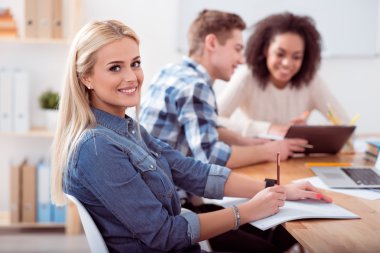 Young smiling woman sitting at the table