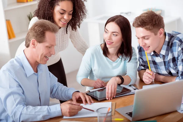 Netter Lehrer sitzt mit seinen Schülern — Stockfoto