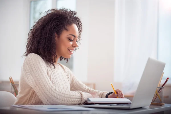 Nette junge Frau studiert am Tisch — Stockfoto