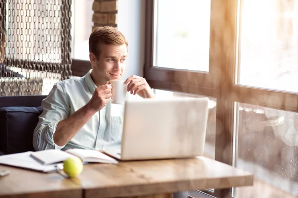 Hombre guapo sentado a la mesa — Foto de Stock