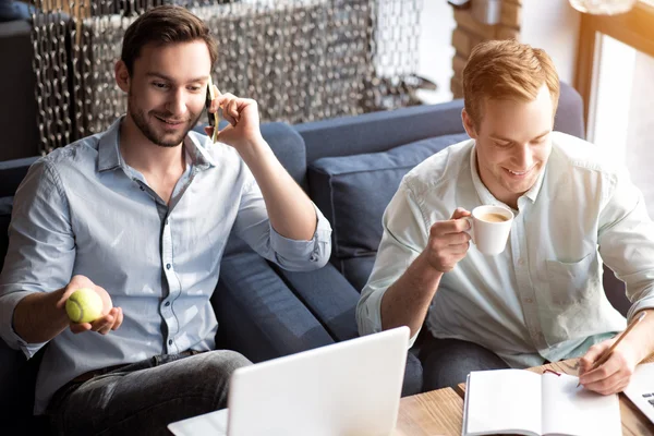 Positive delighted colleagues sitting at the table — Stock Photo, Image