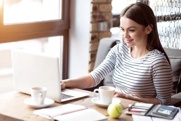 Mujer positiva sentada a la mesa — Foto de Stock