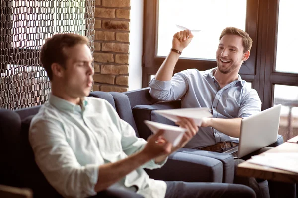 Colegas positivas jugando con aviones de papel — Foto de Stock