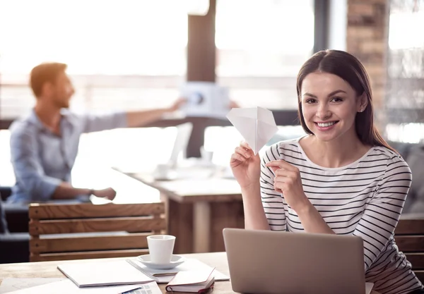 Mulher sorrindo positivo sentado à mesa — Fotografia de Stock