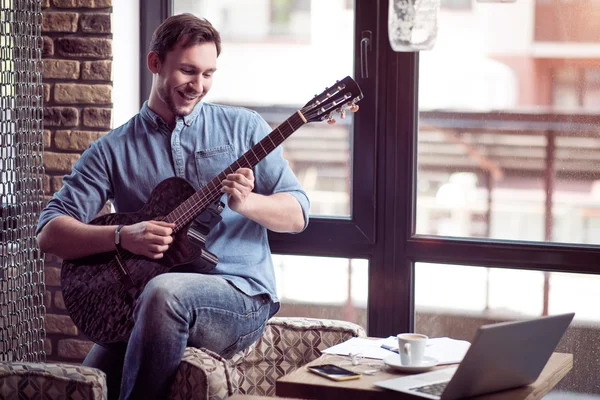 Hombre sonriente positivo tocando la guitarra — Foto de Stock