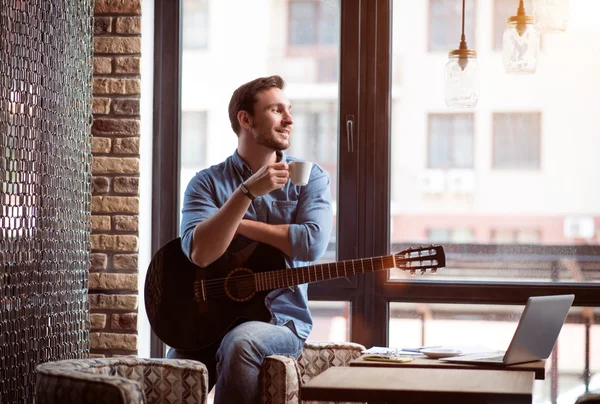 Hombre positivo sosteniendo la guitarra — Foto de Stock