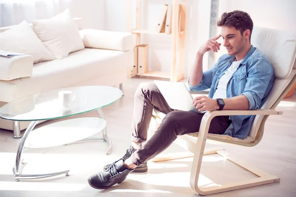 Agradable hombre encantado sentado en el sillón —  Fotos de Stock