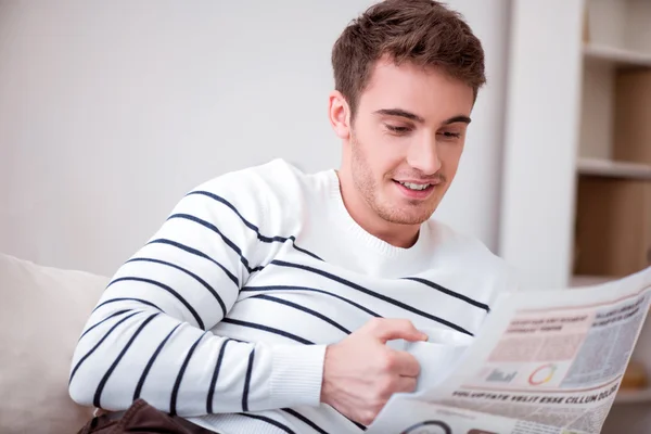 Angenehm lächelnder Mann auf dem Sofa sitzend — Stockfoto