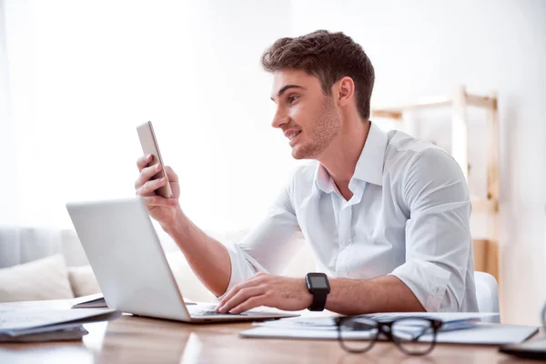 Agradable hombre guapo sentado a la mesa — Foto de Stock