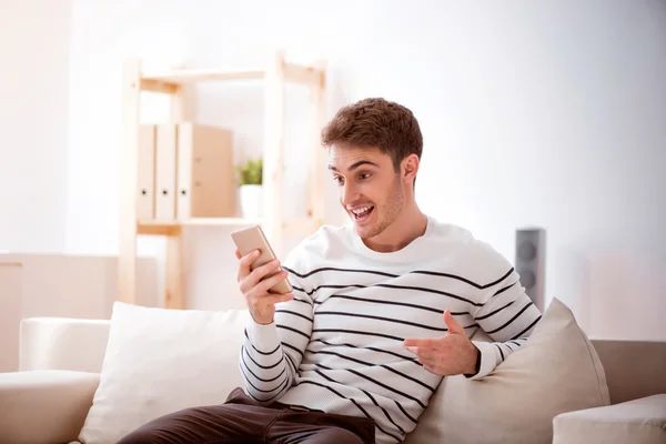 Agradável sorridente homem sentado no sofá — Fotografia de Stock