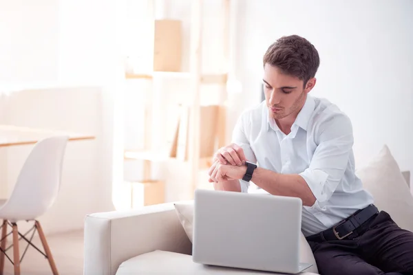 Agradable hombre mirando su reloj inteligente — Foto de Stock