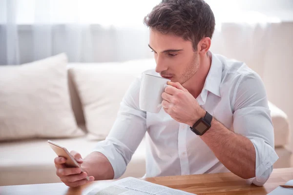 Agradable hombre guapo sentado a la mesa —  Fotos de Stock