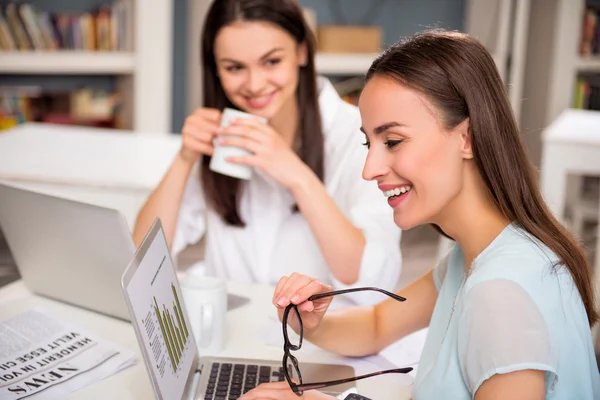 Colegas positivas sentadas a la mesa — Foto de Stock